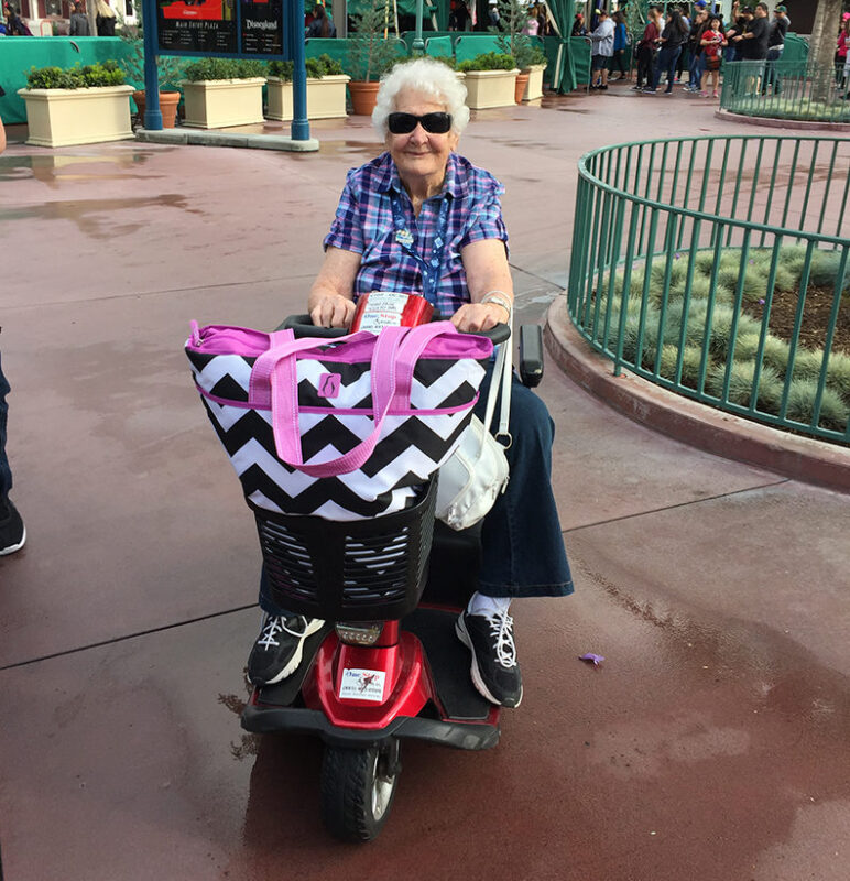 woman scooters around Disneyland