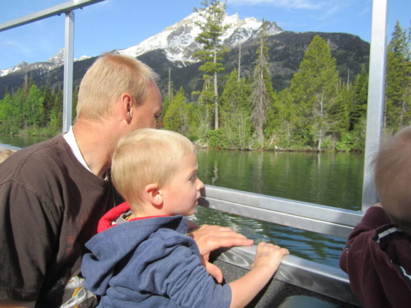 Father and son on Jenny Lake boat in Grand Teton National Park